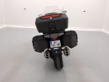 a black motorcycle parked in a room with a white wall