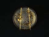 une plaque de verre ornée d'un motif, posée sur un fond noir