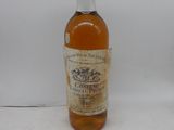 une vieille bouteille de vin posée sur une surface blanche