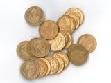 une pile de pièces d'or sur une surface blanche