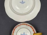 two porcelain plates and a saucer are sitting on a table