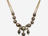un collier en or orné de perles noires et blanches et d'une chaîne en or