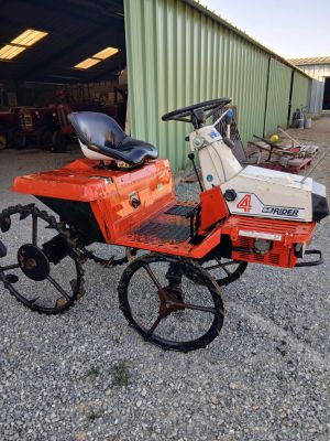 a small lawn mower parked in front of a building