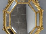 un miroir doré accroché au mur d'une pièce