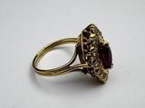 a close up of a gold ring with a red stone