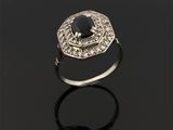 une bague en diamant noir et blanc posée sur une surface noire