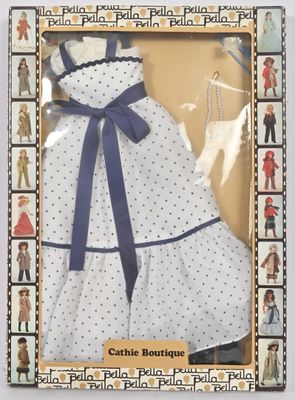 une poupée dans une boîte, vêtue d'une robe et chaussée de souliers