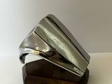 a silver ring sitting on top of a wooden stand