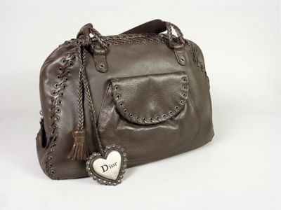 sac à main en cuir marron avec une étiquette en forme de cœur sur la poignée