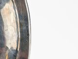 a close up of a silver plate on a white surface