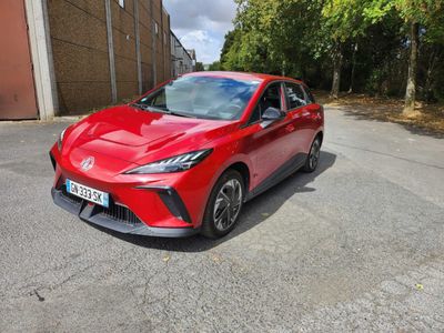 une Toyota Mira rouge garée devant un immeuble