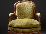 une chaise ancienne dont l'assise est recouverte d'un tissu vert