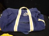 a blue duffel bag with a yellow stripe on it