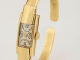 un gros plan d'une montre-bracelet en or au cadran carré