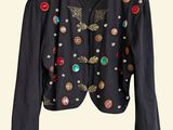 black jacket with buttons and buttons on it hanging on a hanger