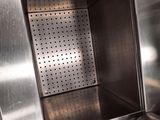a stainless steel oven with a door open on a wooden floor