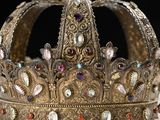 crown made of gold with jewels and gems on a white surface