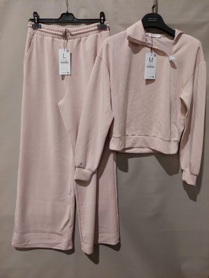two pieces of pink clothing hang on a hanger on a wall