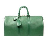 un sac de voyage vert posé sur une surface blanche