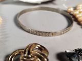 a bracelet, ring, and other jewelry sitting on a table