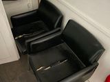 two black leather chairs in a room with a fire hydrant