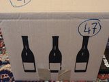 a cardboard box with three bottles of wine in it