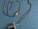 un gros plan d'un collier posé sur un tissu bleu, avec une étiquette de prix