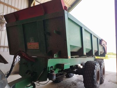 a green dump truck that is parked in a garage