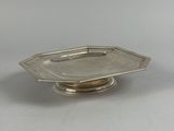 une petite assiette en argent ornée d'un motif de feuilles
