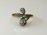 an image of a gold and diamond ring on a white surface
