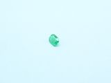a close up of a green gemstone on a white surface