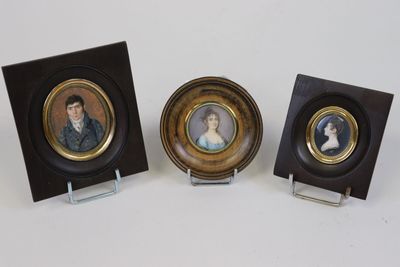 Trois portraits miniatures représentant un homme et une femme sont exposés