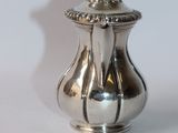 a silver vase with a lid on a white surface