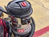 a red and black vacuum sitting on the floor in a room