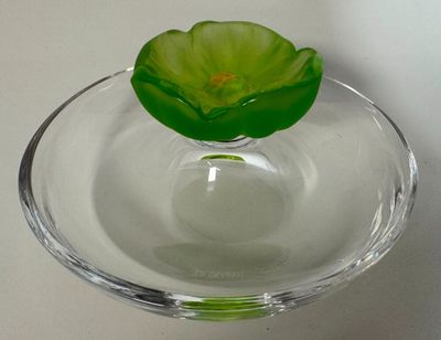 un bol en verre contenant une fleur, posé sur une table