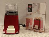 a red blender sitting next to a box of popcorn
