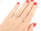 a woman ' s hand with a red manicure holding a diamond ring