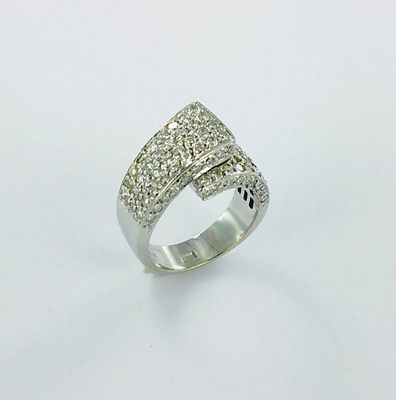 gros plan d'une bague avec des diamants sur une surface blanche