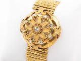 an image of a close up of a gold watch on a white napkin