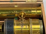 a wooden box with a brass telescope inside of it