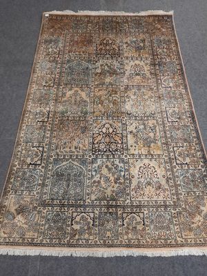 un tapis persan ancien aux motifs bleus et beiges