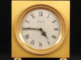 une horloge en or avec des chiffres romains sur le cadran