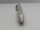 a silver pen that is laying on a white surface