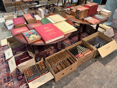de nombreux livres posés sur une table, avec de nombreuses boîtes contenant ces mêmes livres