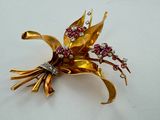 an image of a gold brooch with pink and white flowers