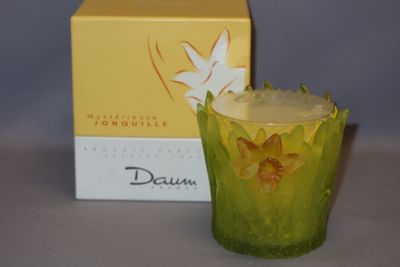 un bougeoir en verre jaune et vert à côté d'une boîte de bougies