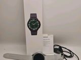 the samsung watch is next to a box and a charger
