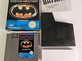 a batman video game on a table next to a book