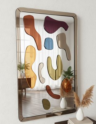 a mirror on the wall above a table with a vase on it