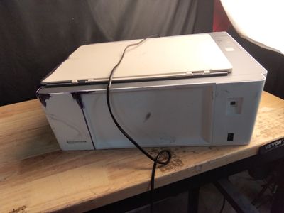 un ordinateur portable posé sur un micro-ondes, lui-même posé sur une table